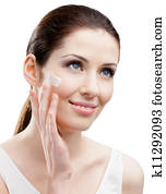 Woman applying cream on her face