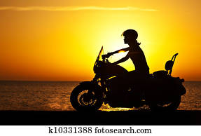 Woman biker over sunset Woman biker over sunset