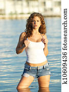 Woman in jeans shorts and a tank top.