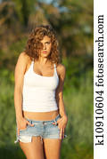 Woman in jeans shorts and a tank top.