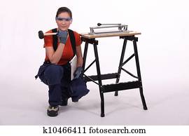 Woman kneeling with mallet Stock Photo | k10460587 