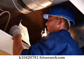 Worker fixing a furnace Worker fixing a furnace