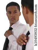 Young businessman adjusting tie before interview