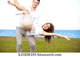 Young Couple Looking Happy Having Fun at the Beach Young Couple Looking Happy Having Fun at the Beach