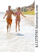 Young couple running along the beach