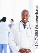 Young doctor wearing a tie under his white lab coat 
