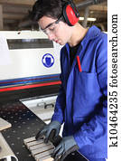Young factory worker preparing machine