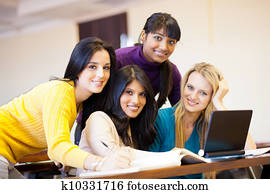 young female college students using laptop in classroom