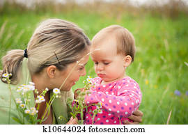 Young mother and her baby girl playing while outdoors on a walk