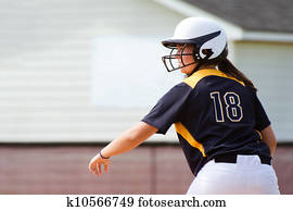 Young teen girl playing softball in organized game