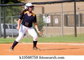 Young teen girl playing softball in organized game