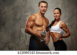 Athletic man and woman with a dumbbells.