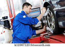 auto mechanic at wheel alignment work with spanner auto mechanic at wheel alignment work with spanner