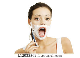 Beautiful young woman shaving her face Beautiful young woman shaving her face