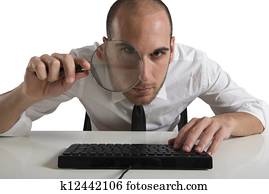 Businessman looks on the computer with a lens Businessman looks on the computer with a lens