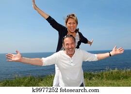Cheerful couple stretching arms in front of the sea