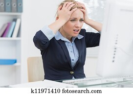 Frustrated business woman in front of computer at office desk Frustrated business woman in front of computer at office desk