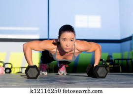 Gym woman push-up strength pushup with dumbbell Gym woman push-up strength pushup with dumbbell