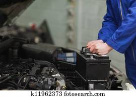 Mechanic changing car battery Mechanic changing car battery