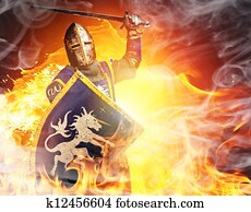 Medieval knight in attack position on fire background. Medieval knight in attack position on fire background.