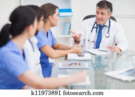 Meeting between a doctor and three nurses and a doctor smiling