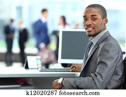 Portrait of a happy African American entrepreneur displaying computer laptop in office Portrait of a happy African American entrepreneur displaying computer laptop in office