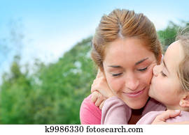 Portrait of little girl giving kiss to her mom Portrait of little girl giving kiss to her mom