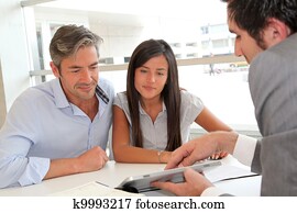 Real-estate agent showing house plans on electronic tablet