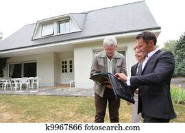 Real-estate agent with senior couple buying new house