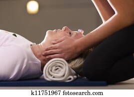 Reiki therapy with girl working as spirit healer, arranging crystals and gemstones on female client for treatment Reiki therapy with girl working as spirit healer, arranging crystals and gemstones on female client for treatment