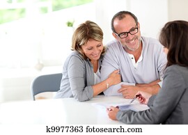 Senior couple signing financial contract