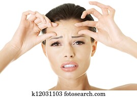 Woman checking her wrinkles on her forehead