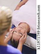 Young therapist doing reiki therapy to senior woman