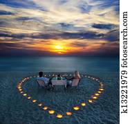 A young couple share a romantic dinner on the beach A young couple share a romantic dinner on the beach