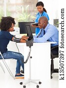 african doctor measuring patient's blood pressure