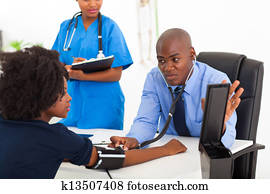 african general practitioner checking patient's blood pressure