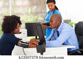 african medical doctor monitoring patient's blood pressure