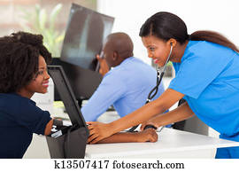 african medical nurse measuring patient's blood pressure