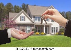 Agent Handing Over the House Keys in Front of New Home Agent Handing Over the House Keys in Front of New Home