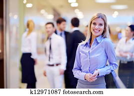 business woman with her staff in background at office