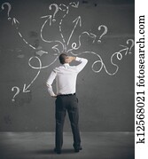 Businessman looking at arrows pointed in different directions Businessman looking at arrows pointed in different directions