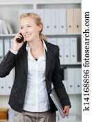 Businesswoman Holding Laptop While Using Mobile Phone