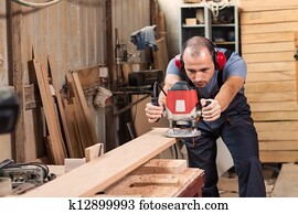 Carpenter with an electric router Carpenter with an electric router