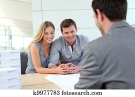 Couple in real-estate agency talking to construction planner
