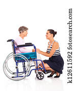 daughter talking to disabled senior mother