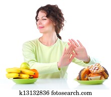 Diet. Beautiful Young Woman choosing between Fruits and Sweets Diet. Beautiful Young Woman choosing between Fruits and Sweets