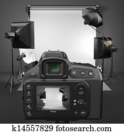 Digital photo camera in studio with softbox and flashes.