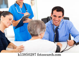 doctor checking senior patient's blood pressure