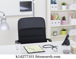 Doctor office table desk and black chair with stethoscope  and white paper