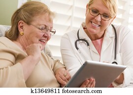 Doctor or Nurse Talking to Senior Woman with Touch Pad